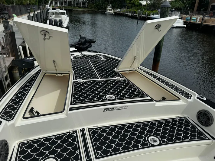  Yacht Photos Pics 2024 Pathfinder 2500 Hybrid boat with open storage compartments on a calm waterway.