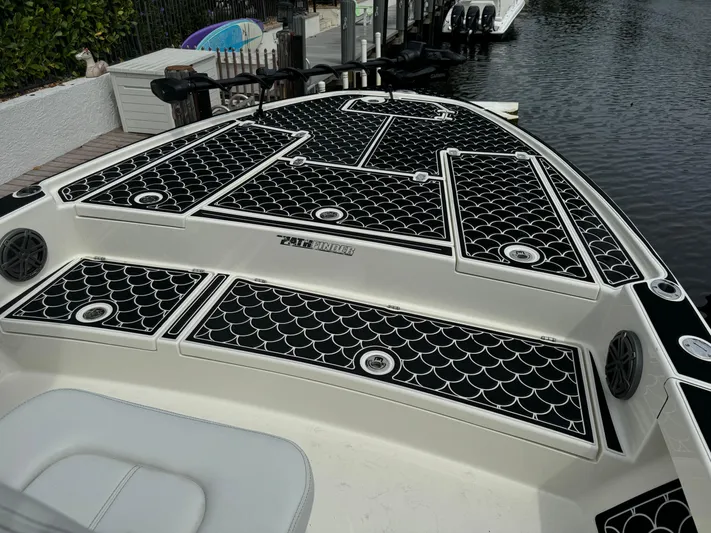  Yacht Photos Pics 2024 Pathfinder 2500 Hybrid boat with black and white deck design on a calm waterway.