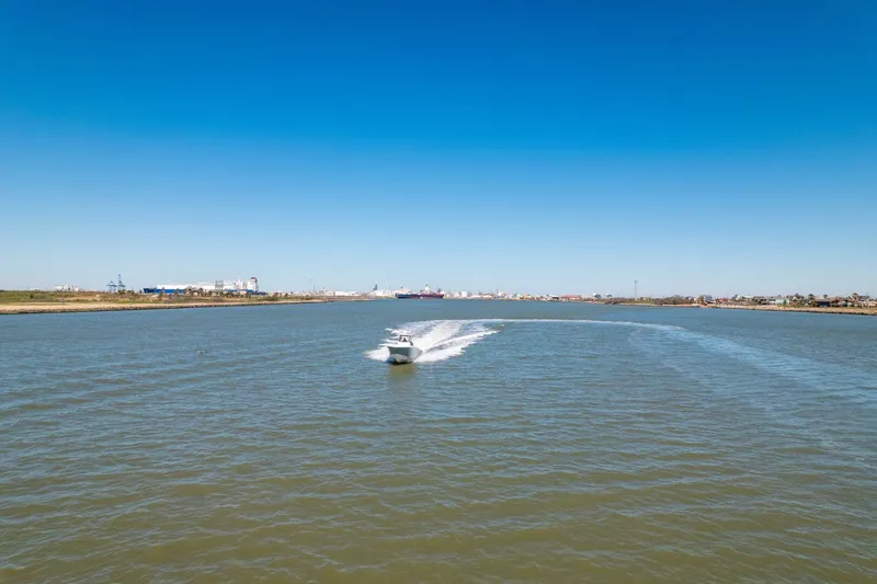  Yacht Photos Pics 2019 Invincible 39 Open Fisherman cruising on a wide river under clear blue skies.