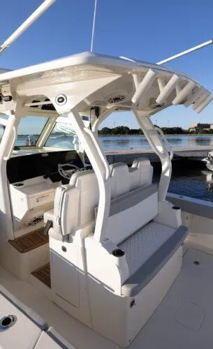  Yacht Photos Pics 2026 Scout 357 LXF boat interior with seating and helm, docked by the water.