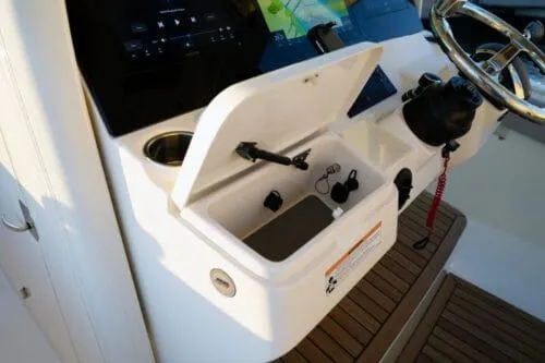 Yacht Photos Pics 2026 Scout 357 LXF boat console with open storage compartment and steering wheel.
