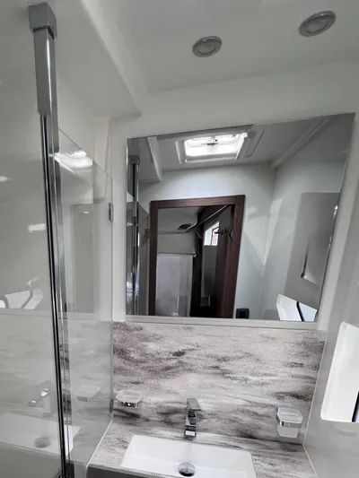 Yacht Photos Pics Modern bathroom interior of 2024 Beneteau M 48 yacht with sleek fixtures and mirror.