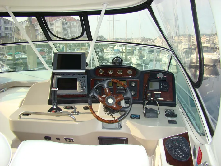 Cramitall Inn Yacht Photos Pics 2004 Cruisers 455 Express Motoryacht helm with navigation equipment and marina view.