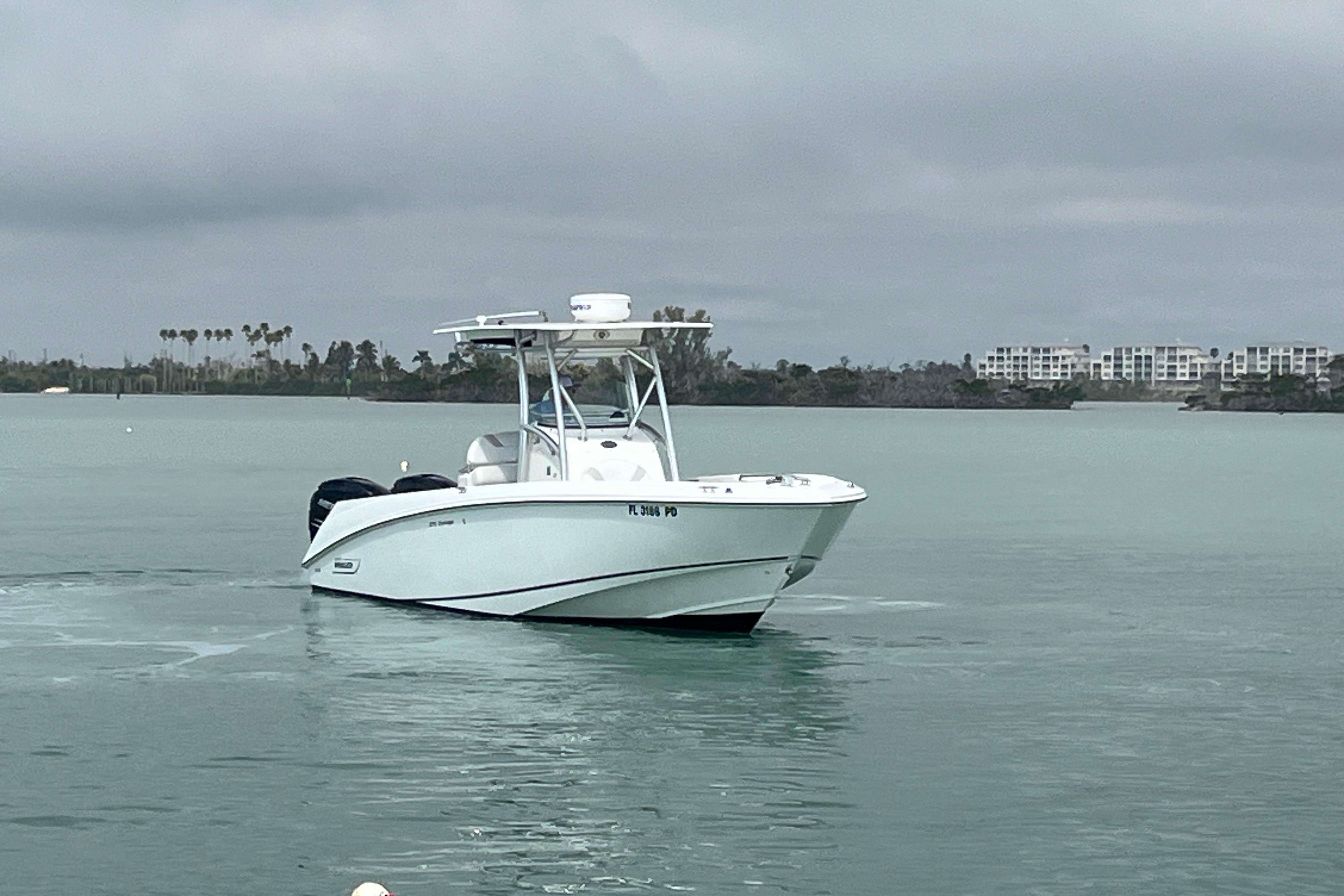 2007 Boston Whaler 270 Outrage boat on calm water with cloudy sky backdrop.