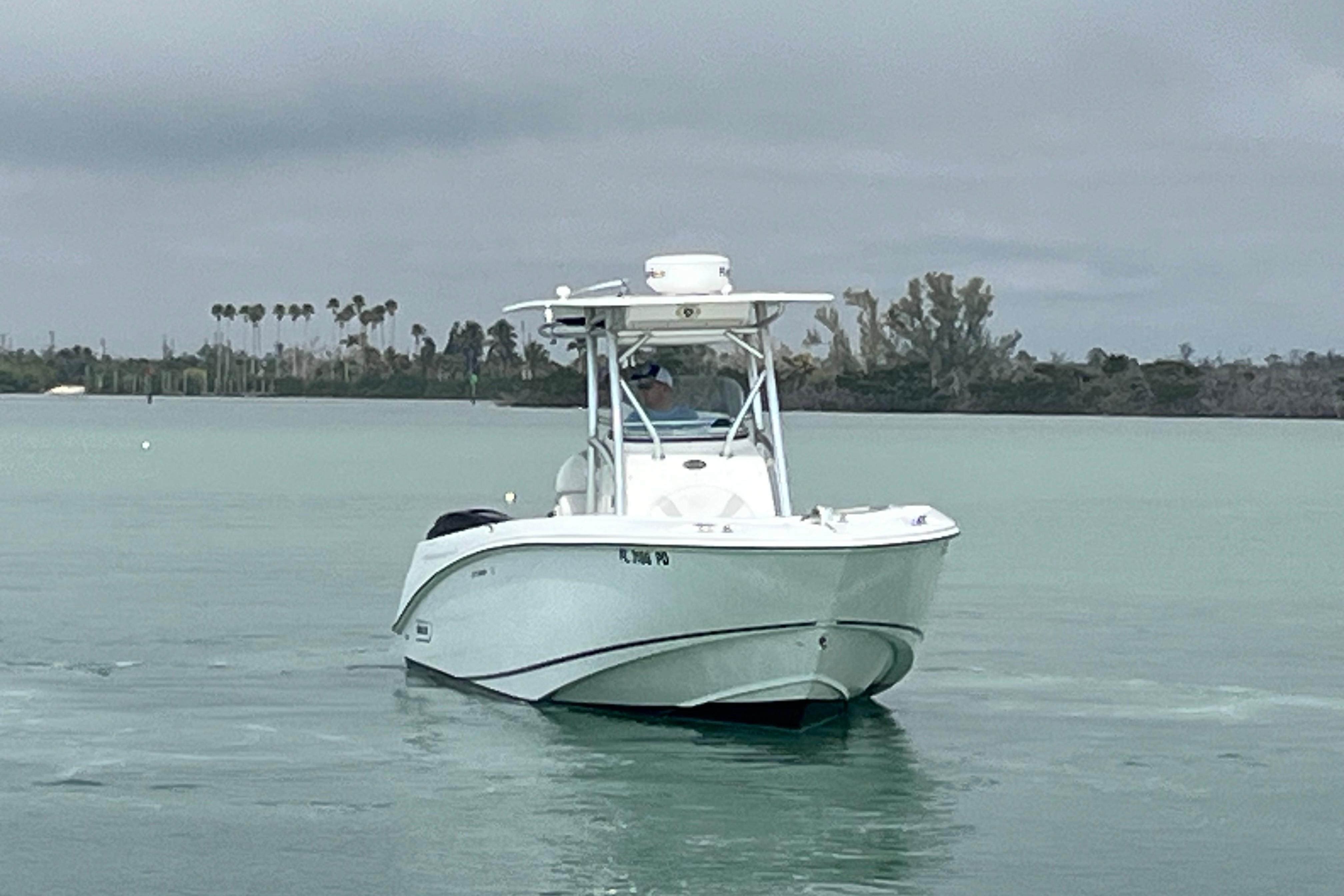 2007 Boston Whaler 270 Outrage boat on calm water with cloudy sky backdrop.
