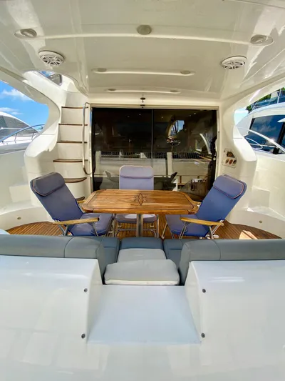Last Minute Yacht Photos Pics 2002 Azimut 55 yacht interior with seating and table, showcasing luxury design.