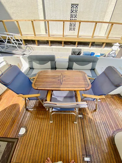 Last Minute Yacht Photos Pics Luxurious 2002 Azimut 55 yacht deck with elegant seating and wooden table.