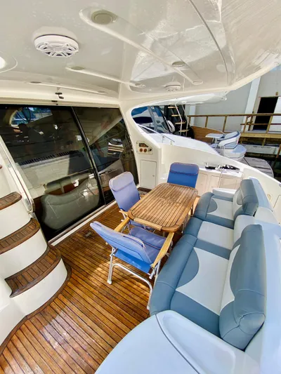 Last Minute Yacht Photos Pics Luxurious 2002 Azimut 55 yacht deck with seating and wooden table.