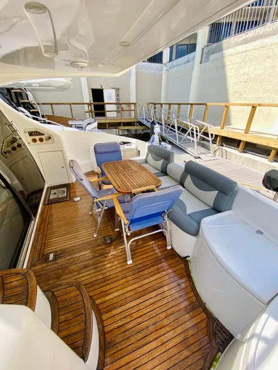 Last Minute Yacht Photos Pics Luxurious 2002 Azimut 55 yacht deck with seating and wooden flooring.