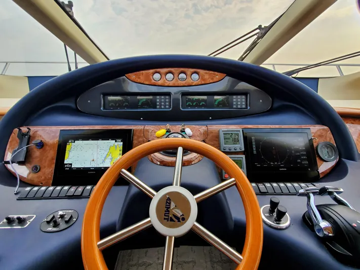 Last Minute Yacht Photos Pics Cockpit of 2002 Azimut 55 yacht with navigation instruments and wooden steering wheel.