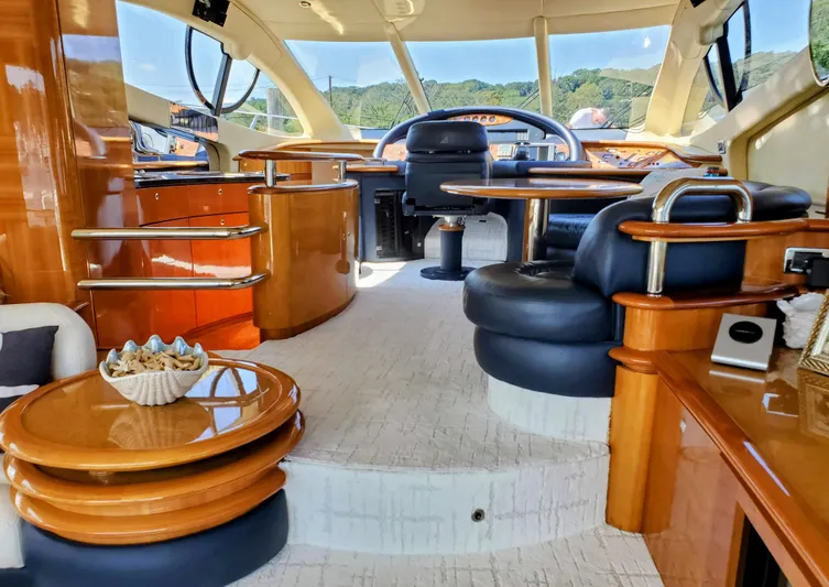 Last Minute Yacht Photos Pics Luxurious interior of a 2002 Azimut 55 yacht with elegant wood finishes and plush seating.