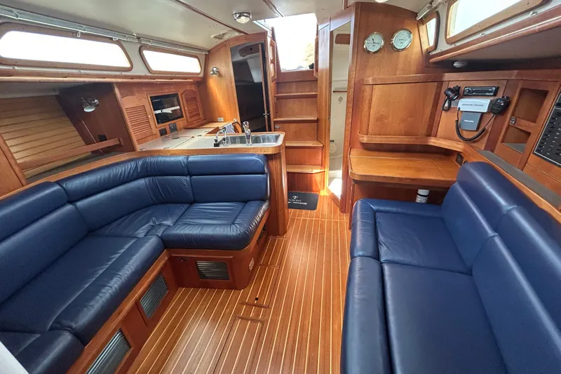 Indigo Yacht Photos Pics Luxurious interior of a 2002 Sabre 362 yacht with blue leather seating and wooden finishes.