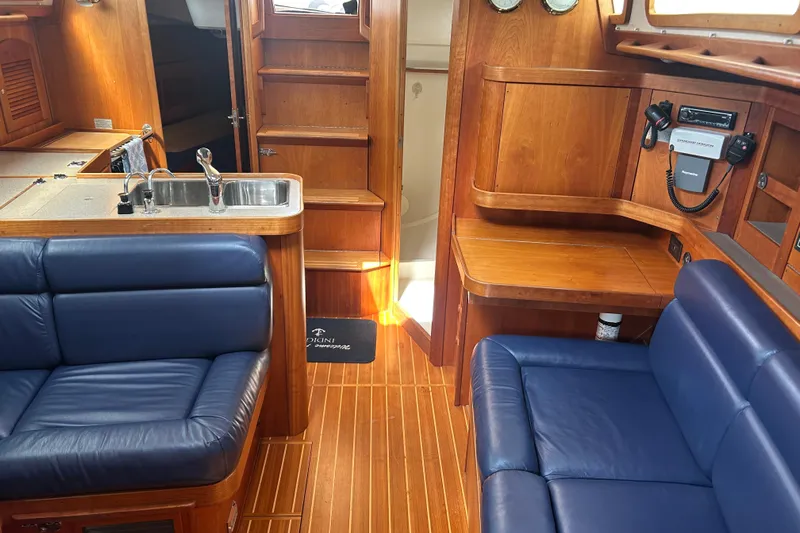 Indigo Yacht Photos Pics Interior of 2002 Sabre 362 yacht with blue seating and wooden finishes.