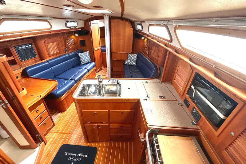 Indigo Yacht Photos Pics Luxurious interior of a 2002 Sabre 362 yacht with wooden finishes and blue seating.