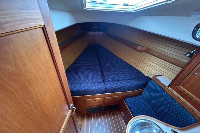 Indigo Yacht Photos Pics Cozy cabin interior of 2002 Sabre 362 sailboat with wood paneling and blue cushions.