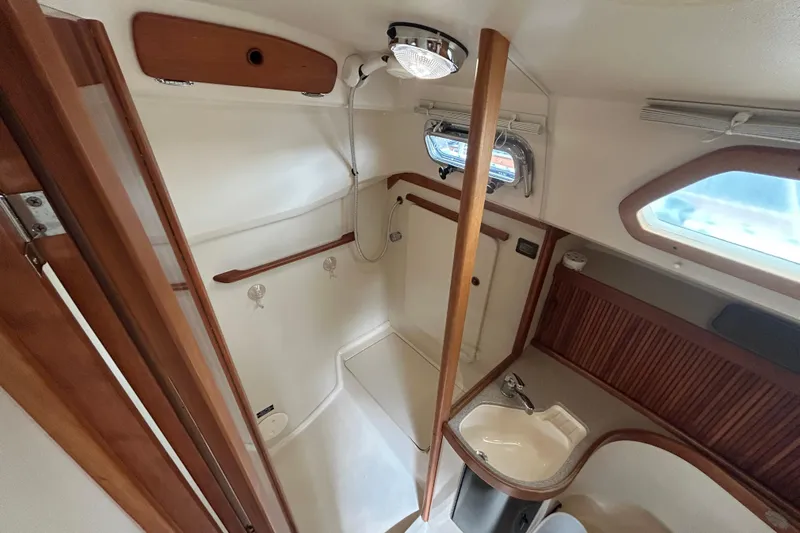 Indigo Yacht Photos Pics 2002 Sabre 362 yacht bathroom interior with shower, sink, and wooden accents.