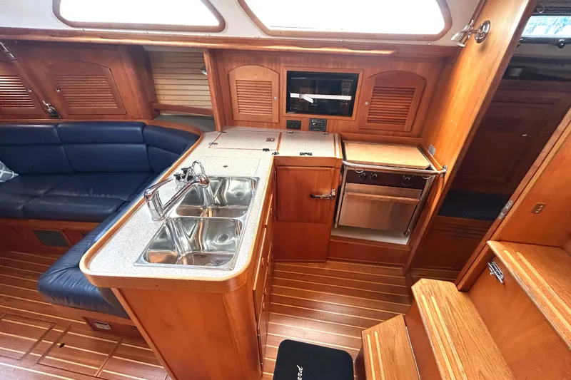 Indigo Yacht Photos Pics Interior of 2002 Sabre 362 yacht featuring a wooden galley with sink and seating area.