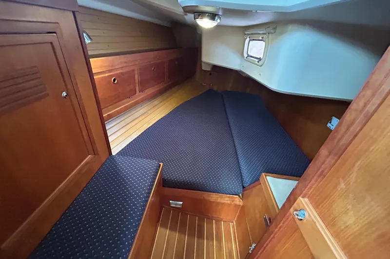 Indigo Yacht Photos Pics Cozy cabin interior of 2002 Sabre 362 sailboat with wooden finish and cushioned seating.