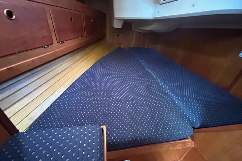 Indigo Yacht Photos Pics 2002 Sabre 362 interior cabin with blue polka dot cushions and wooden storage cabinets.