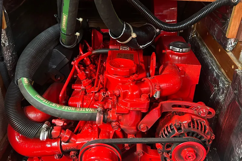 Indigo Yacht Photos Pics Red engine of a 2002 Sabre 362 sailboat with visible hoses and components.