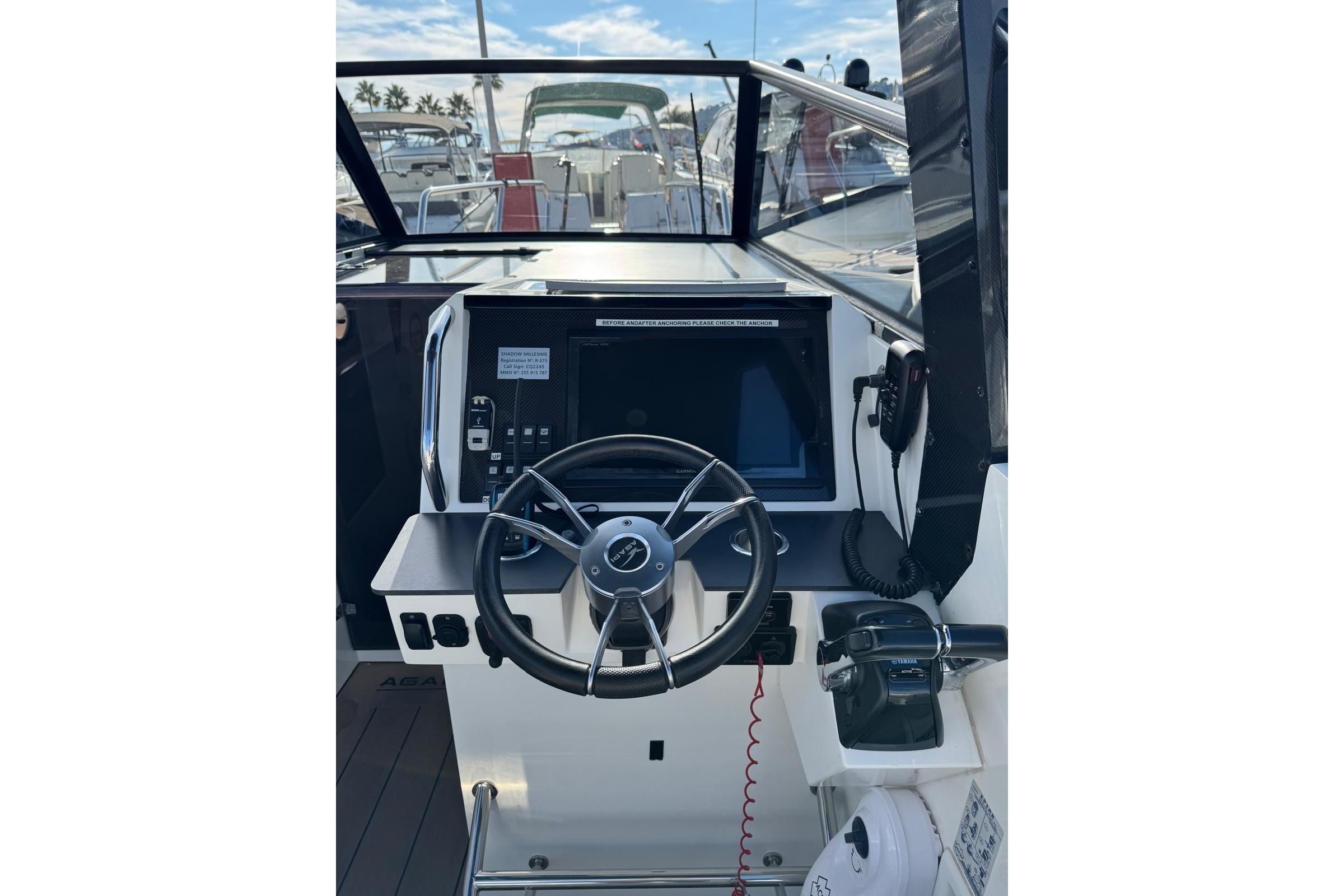 Cockpit of 2019 Agapi 950 boat with steering wheel and navigation controls.