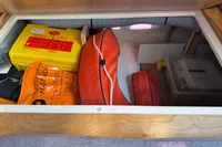 Storage compartment in a 2019 Agapi 950 boat with safety equipment and first aid kit.
