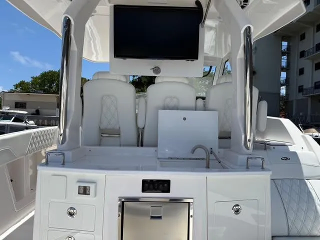  Yacht Photos Pics 2023 Regal 33 SAV boat interior with luxurious seating, sink, and mounted screen.