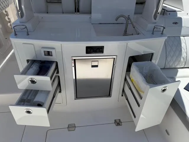  Yacht Photos Pics 2023 Regal 33 SAV boat kitchen area with sink, storage drawers, and trash compartment.
