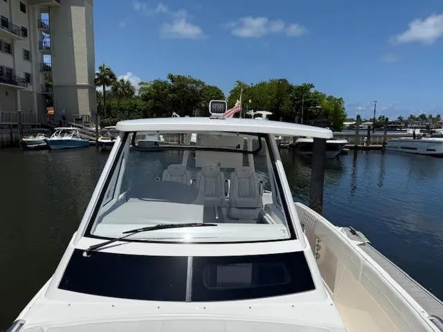  Yacht Photos Pics 2023 Regal 33 SAV boat docked in a marina under a clear blue sky.