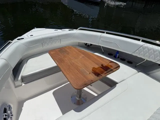  Yacht Photos Pics 2023 Regal 33 SAV boat with wooden table and white seating in the deck area.
