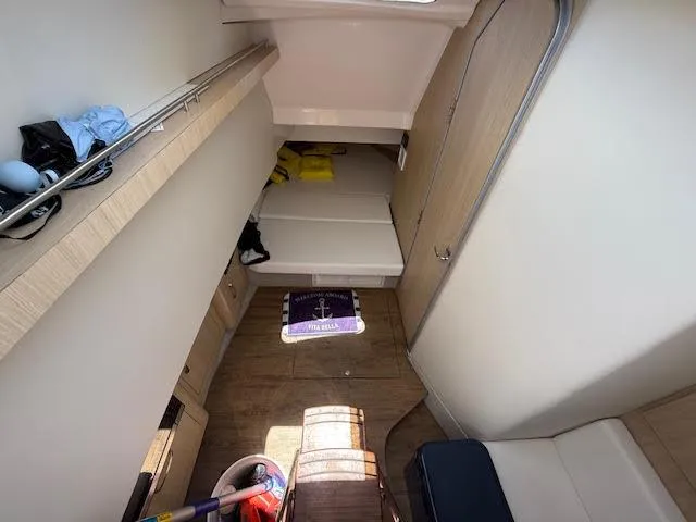  Yacht Photos Pics 2023 Regal 33 SAV cabin interior with wooden flooring and compact sleeping area.