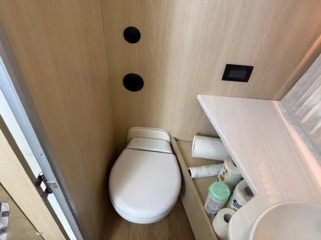  Yacht Photos Pics Compact bathroom in 2023 Regal 33 SAV boat with toilet and storage shelves.