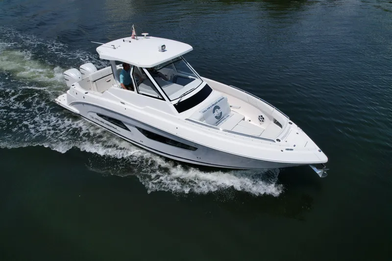  Yacht Photos Pics 2023 Regal 33 SAV boat cruising on calm water, showcasing sleek design and powerful engines.