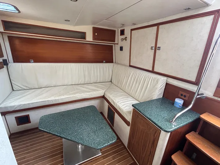 No Slack Yacht Photos Pics Interior of 2002 Albemarle 410 Express Fisherman with white seating and wooden accents.