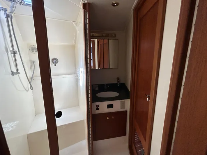 No Slack Yacht Photos Pics 2002 Albemarle 410 Express Fisherman bathroom with shower, sink, and wooden cabinetry.