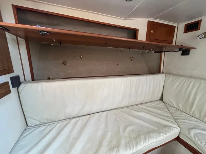 No Slack Yacht Photos Pics Interior of 2002 Albemarle 410 Express Fisherman with white cushioned seating and storage.