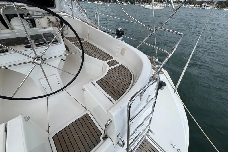 A Domani Yacht Photos Pics 2002 Beneteau Oceanis 411 sailboat cockpit with steering wheel and teak flooring.