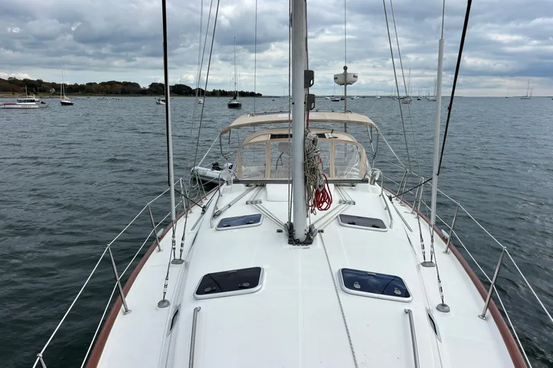 A Domani Yacht Photos Pics 2002 Beneteau Oceanis 411 sailboat on calm waters under cloudy skies.
