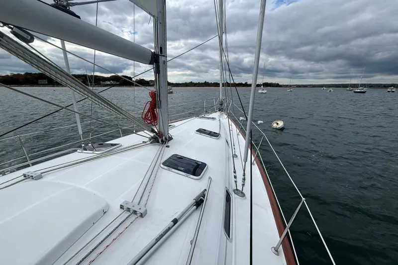 A Domani Yacht Photos Pics 2002 Beneteau Oceanis 411 sailboat on calm waters under cloudy skies.