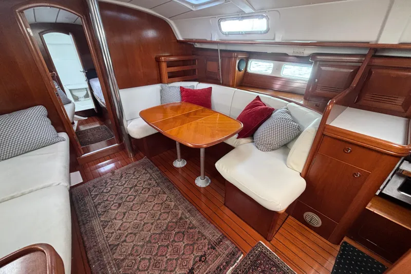 A Domani Yacht Photos Pics Luxurious interior of 2002 Beneteau Oceanis 411 sailboat with cozy seating and wooden finishes.