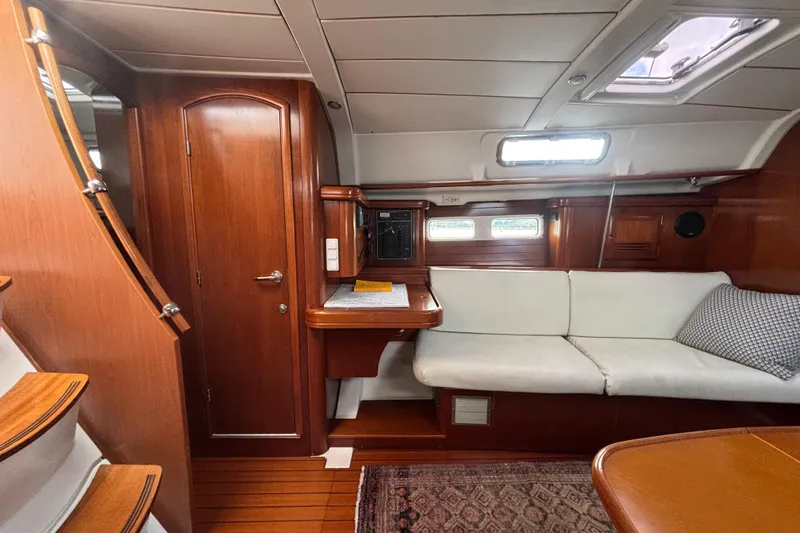 A Domani Yacht Photos Pics Interior of 2002 Beneteau Oceanis 411 yacht with wooden finish and white seating.