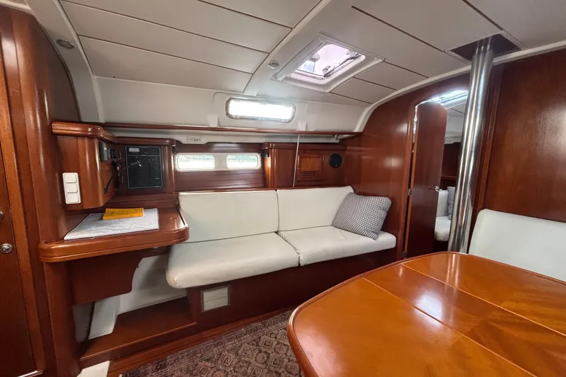 A Domani Yacht Photos Pics Interior of 2002 Beneteau Oceanis 411 yacht with wooden finish and white seating.