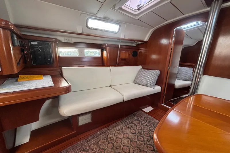A Domani Yacht Photos Pics Interior of 2002 Beneteau Oceanis 411 sailboat with wooden finish and white seating.