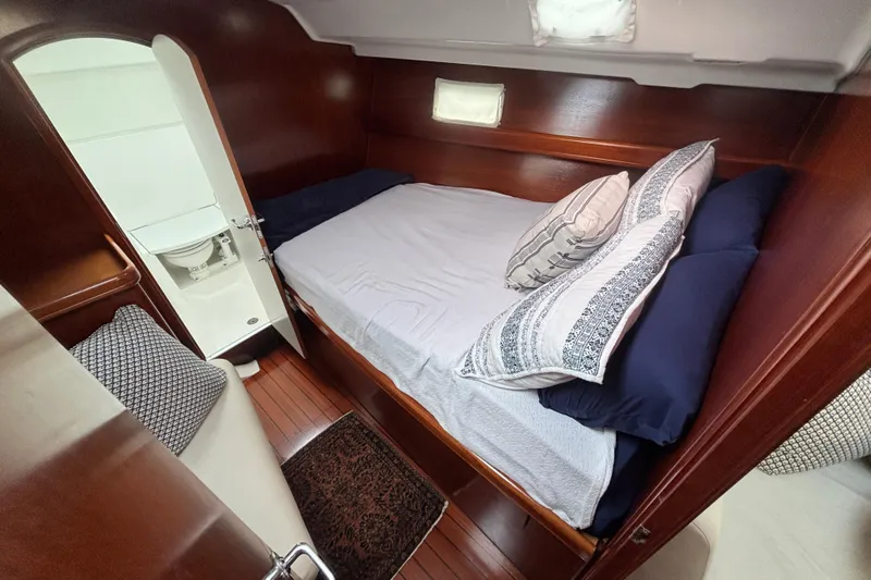 A Domani Yacht Photos Pics Cozy cabin interior of 2002 Beneteau Oceanis 411 sailboat with bed and ensuite bathroom.