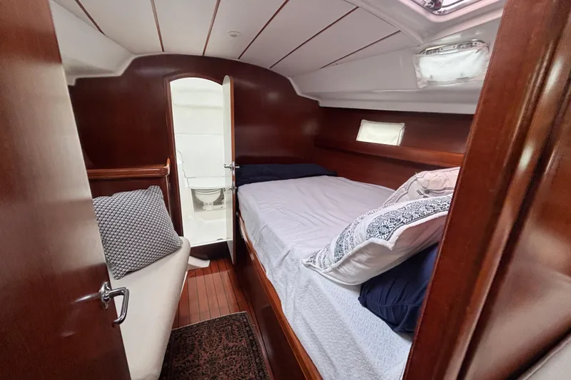 A Domani Yacht Photos Pics Cozy cabin interior of 2002 Beneteau Oceanis 411 sailboat with bed and bathroom.