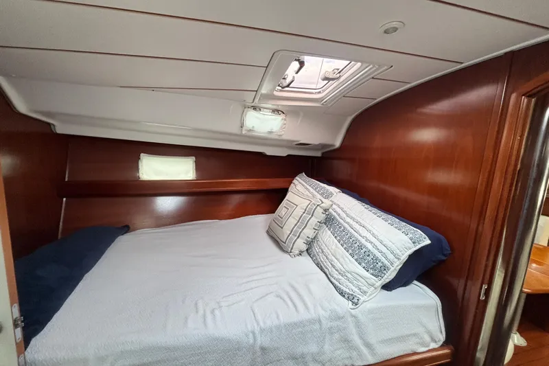A Domani Yacht Photos Pics Cozy cabin interior of 2002 Beneteau Oceanis 411 sailboat with bed and wooden finish.