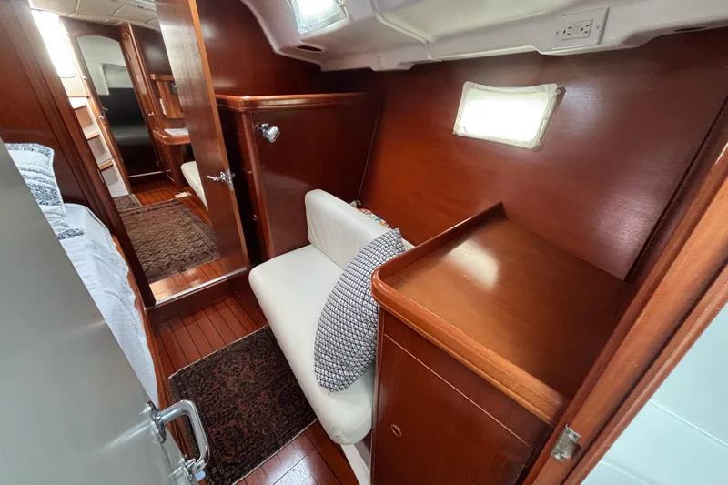 A Domani Yacht Photos Pics Interior of 2002 Beneteau Oceanis 411 yacht, featuring wood paneling and cozy seating area.