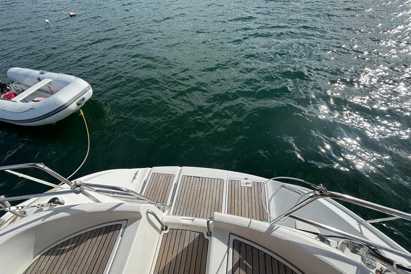 A Domani Yacht Photos Pics Beneteau Oceanis 411 yacht deck with inflatable dinghy on water, 2002 model.