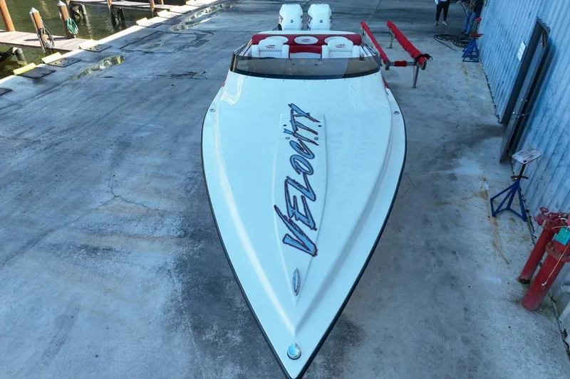  Yacht Photos Pics 2022 Velocity 290sc speedboat on concrete dock, showcasing sleek design and branding.