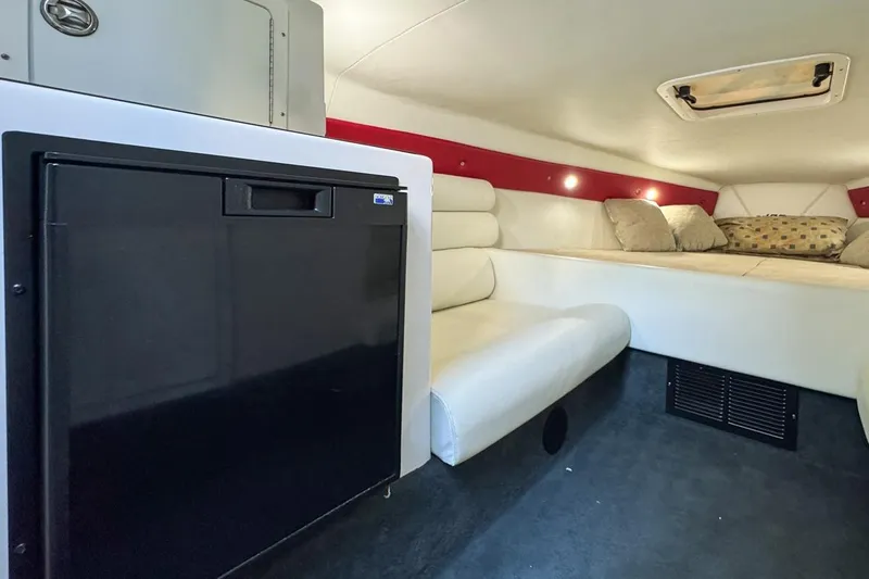  Yacht Photos Pics 2022 Velocity 290sc cabin interior with seating, bed, and compact refrigerator.